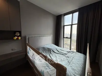 Cozy bedroom with large window offering stunning city views, perfect for relaxation and comfort.
