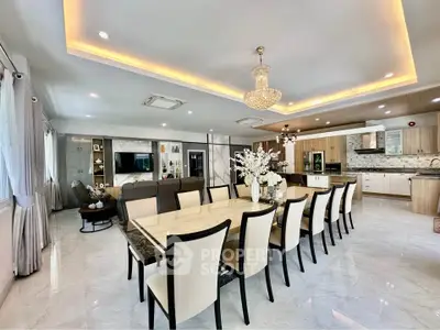 Luxurious open-plan living and dining area with elegant chandelier and modern kitchen.