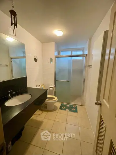 Modern bathroom with sleek fixtures and frosted glass shower in a cozy residential setting.