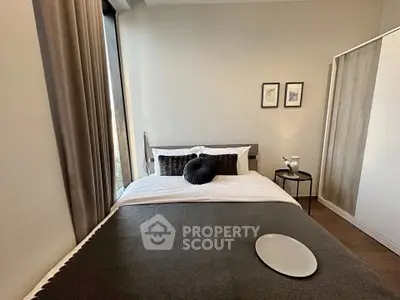 Modern bedroom with stylish decor and large window offering natural light