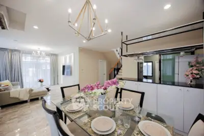 Luxurious open-plan living and dining area with elegant chandelier and modern decor