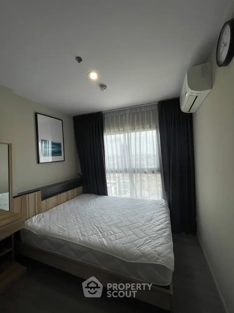 Modern bedroom with large window, stylish decor, and natural light