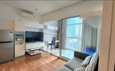 Modern living room with balcony and city view, featuring sleek furniture and wooden flooring.