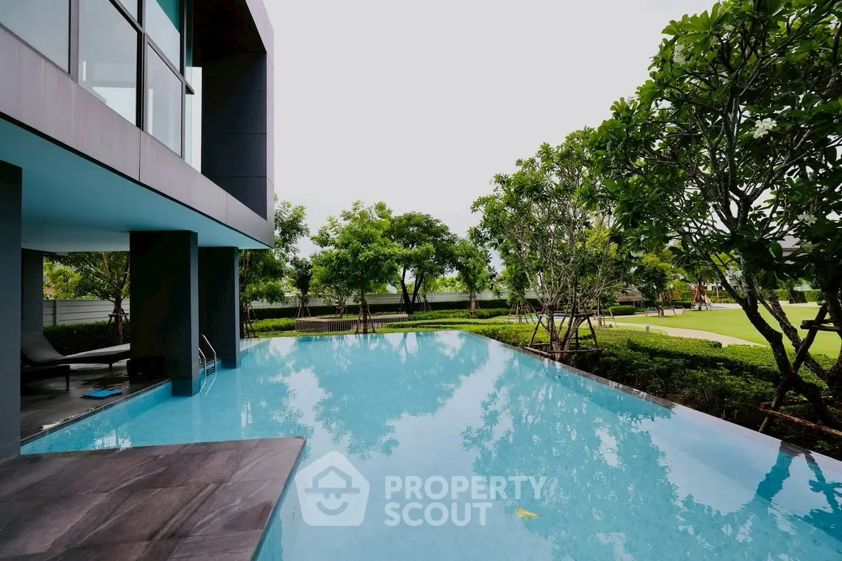 Luxurious modern home with stunning infinity pool and lush garden view.