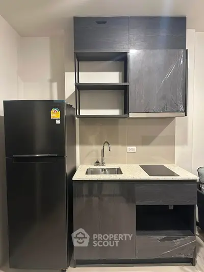 Modern compact kitchen with sleek black appliances and minimalist cabinetry