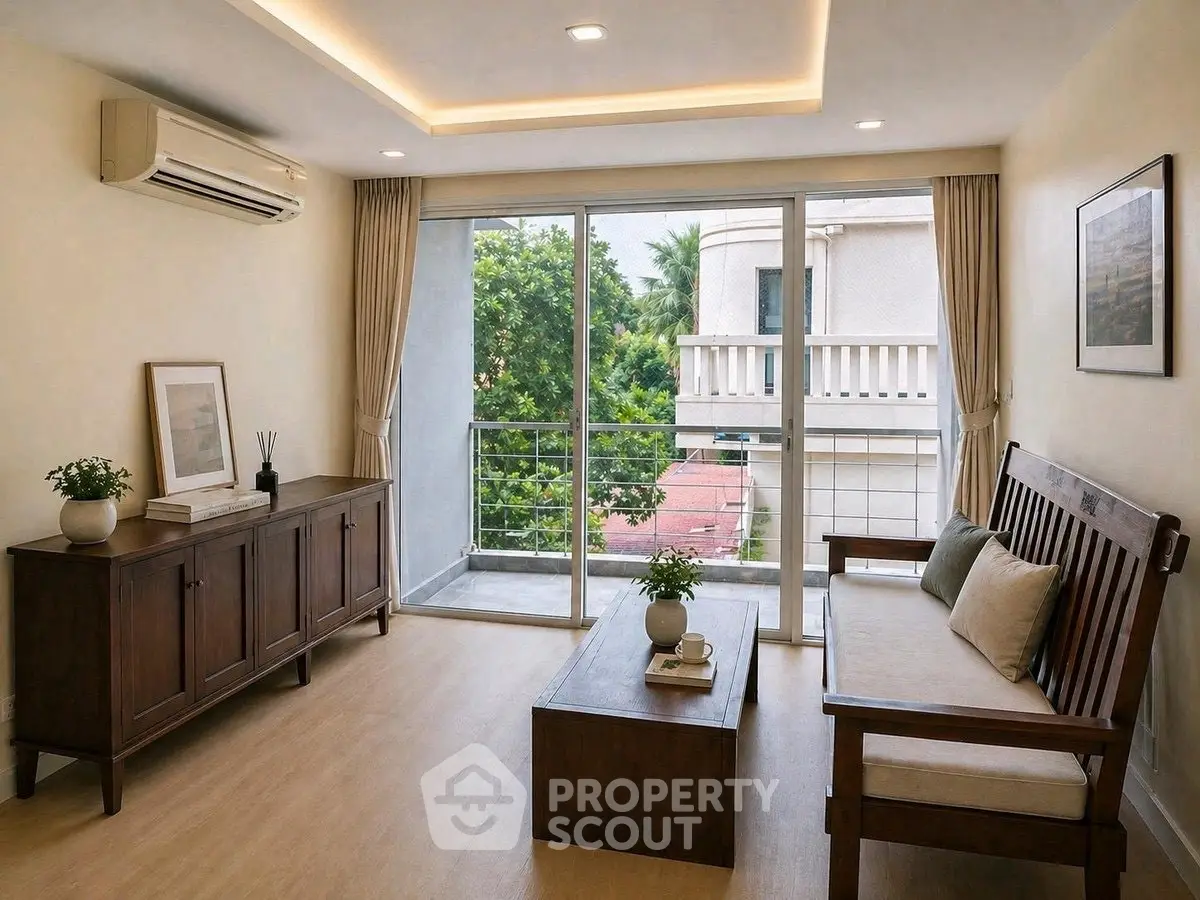 Elegant living room with wooden furniture and large windows offering a serene view.