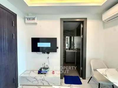 Modern living room with wall-mounted TV and sleek furniture in a contemporary apartment.