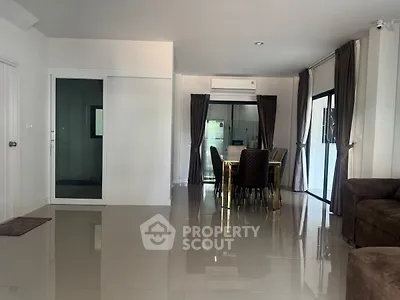 Spacious modern living and dining area with sleek tile flooring and large windows.