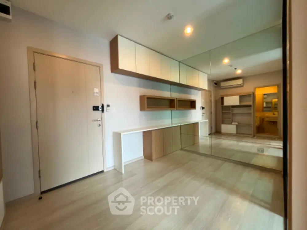 Modern minimalist living room with mirrored wall and built-in storage