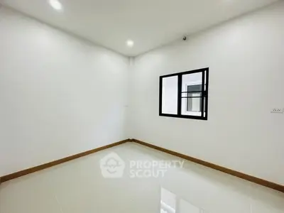 Minimalist empty room with white walls and tiled floor, featuring a single window.