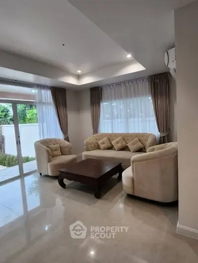 Elegant living room with plush sofas and natural light, perfect for relaxation and entertaining.