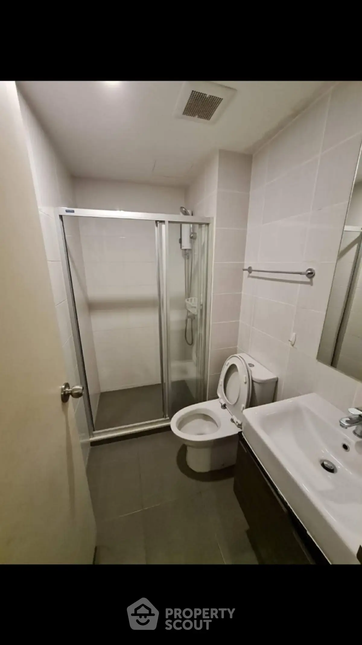Modern bathroom with glass shower and sleek fixtures in contemporary apartment.