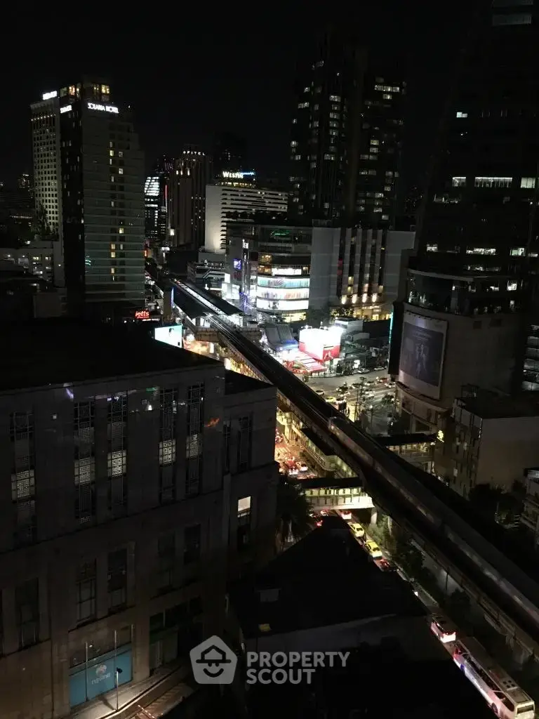 Stunning cityscape view from a high-rise building at night, showcasing vibrant urban lights and architecture.