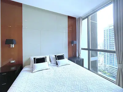 Luxurious bedroom with floor-to-ceiling windows offering stunning city views