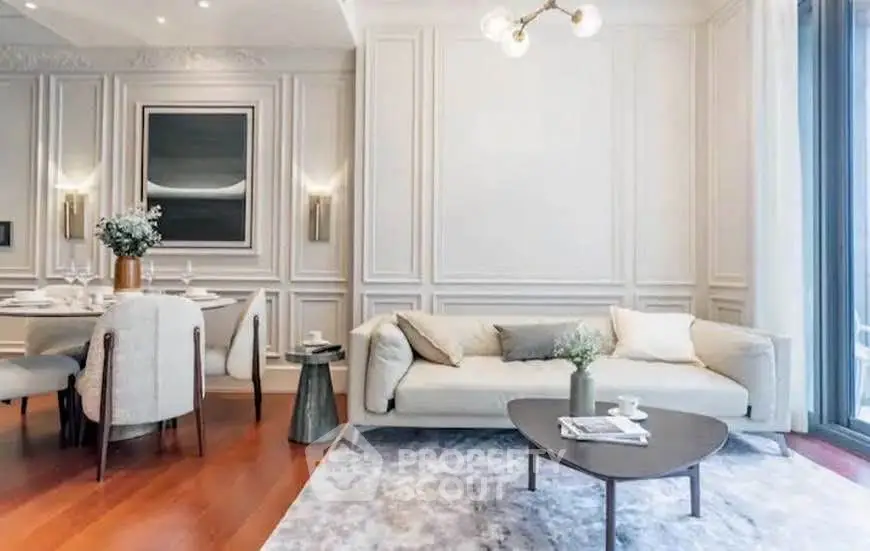 Elegant living room with modern decor, featuring a cozy sofa, stylish dining area, and chic lighting.