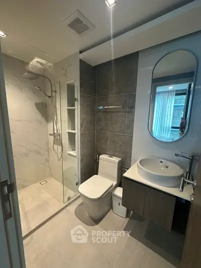 Modern bathroom with sleek design, featuring a glass shower enclosure and stylish vanity.