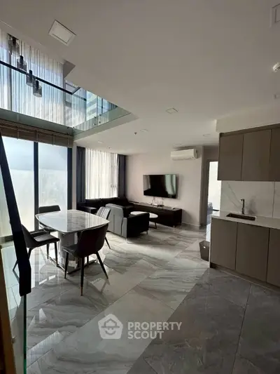 Luxurious modern living room with open kitchen and elegant marble flooring