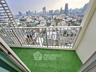 Stunning cityscape view from a high-rise balcony with artificial grass flooring.