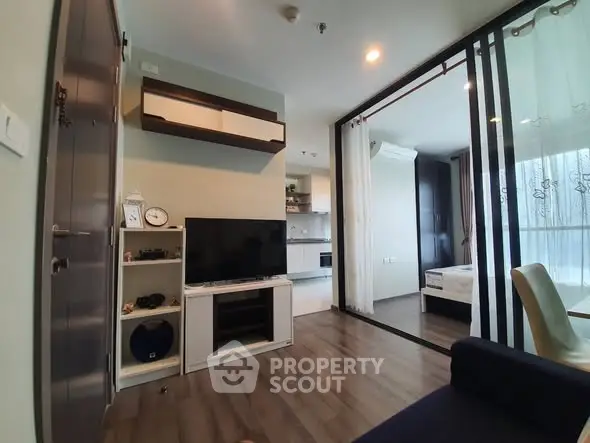 Modern apartment living room with open kitchen and bedroom view