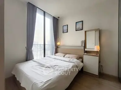 Cozy bedroom with large window and modern decor in a stylish apartment.