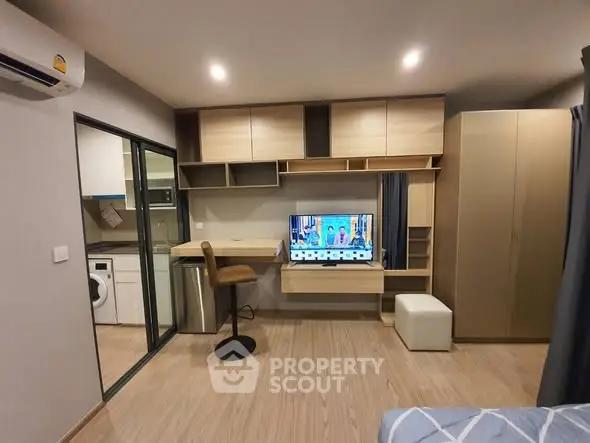 Modern studio apartment with built-in storage and compact workspace