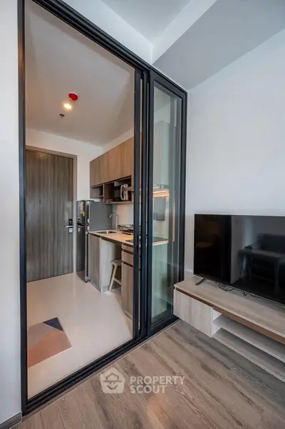 Modern apartment interior with open kitchen and living room, featuring sleek design and contemporary furnishings.