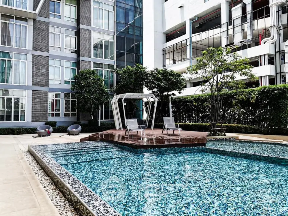 Modern condominium with luxurious pool and stylish outdoor seating area.