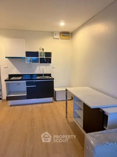 Modern compact kitchen with sleek cabinetry and open layout in a cozy apartment.