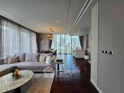 Luxurious open-plan living room with elegant decor and floor-to-ceiling windows offering stunning views.