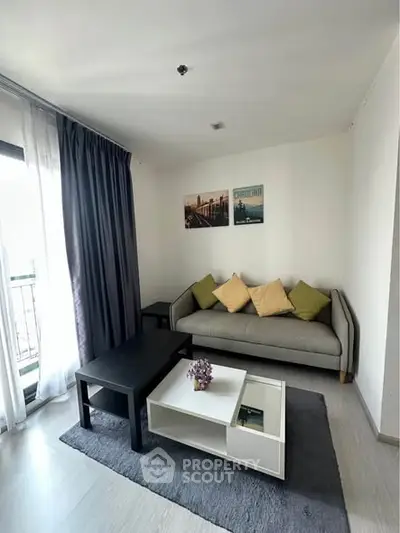 Cozy living room with modern decor and natural light, featuring a comfortable sofa and stylish coffee table.