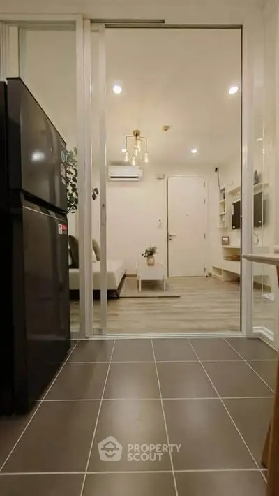 Modern apartment interior with sleek kitchen and cozy living room, featuring stylish lighting and contemporary decor.
