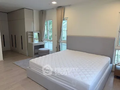 Spacious bedroom with modern design, large windows, and ample storage space.