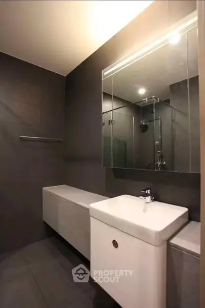 Modern bathroom with sleek design and large mirror in a contemporary apartment.