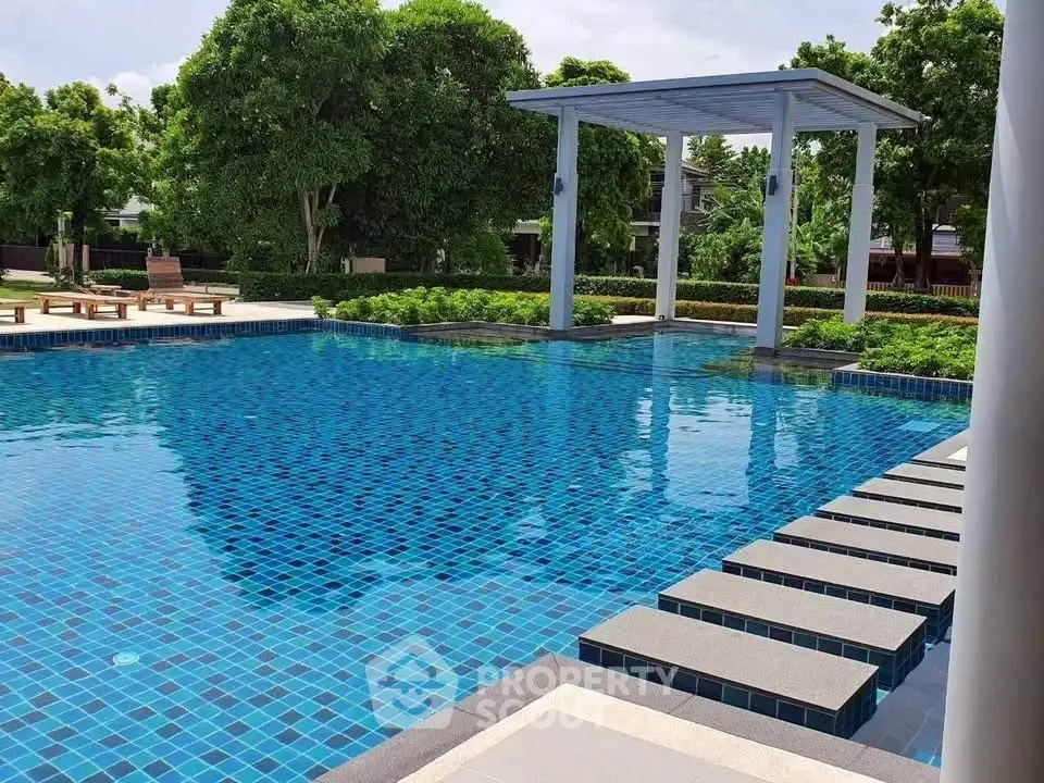 Luxurious outdoor pool with modern design and lush greenery, perfect for relaxation and leisure.