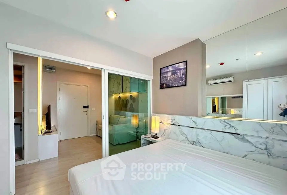Modern bedroom with mirrored wall and stylish decor in a contemporary apartment.