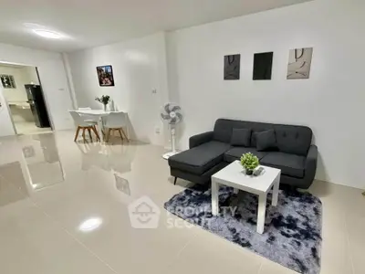 Modern living room with sleek furniture and open dining area, perfect for contemporary living.