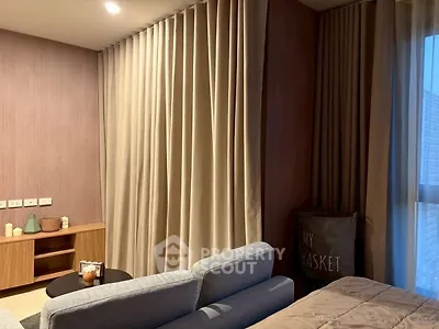 Cozy living room with modern decor and soft lighting, featuring a comfortable sofa and elegant curtains.