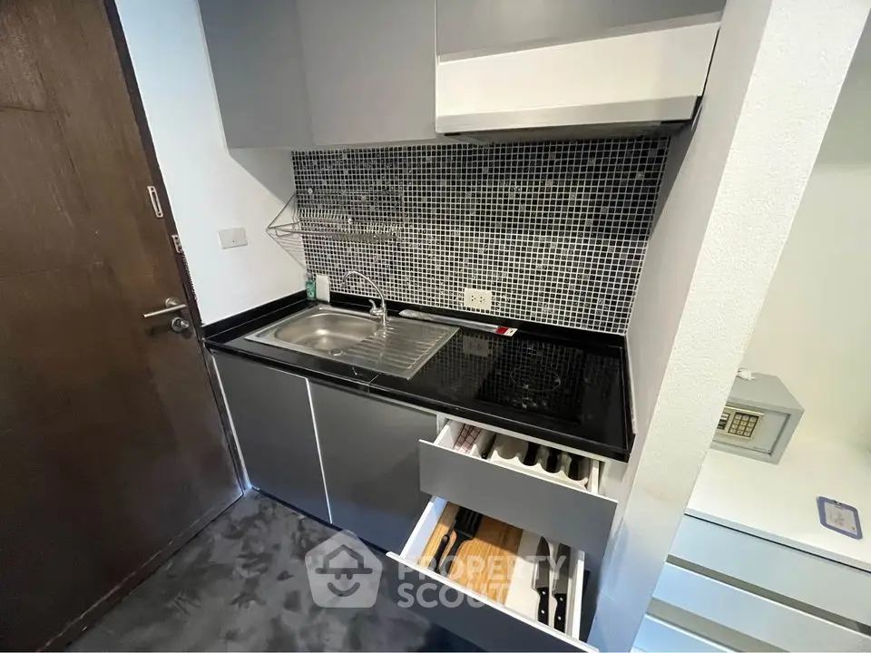 Modern compact kitchen with sleek cabinetry and mosaic backsplash