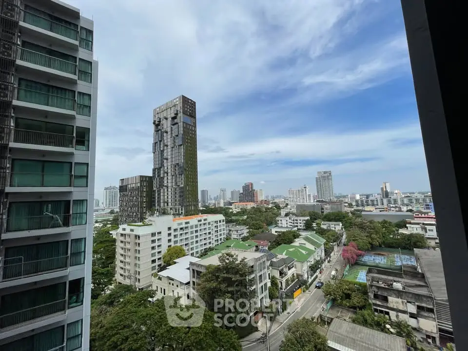 Stunning cityscape view from high-rise apartment balcony with lush greenery and modern architecture.