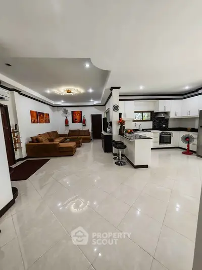 Spacious open-plan living room and kitchen with modern furnishings and elegant decor.