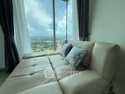 Luxurious living room with panoramic city view from high-rise apartment.