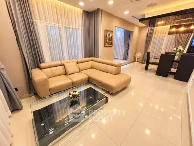 Luxurious modern living room with elegant beige sofa and glass coffee table, perfect for stylish entertaining.