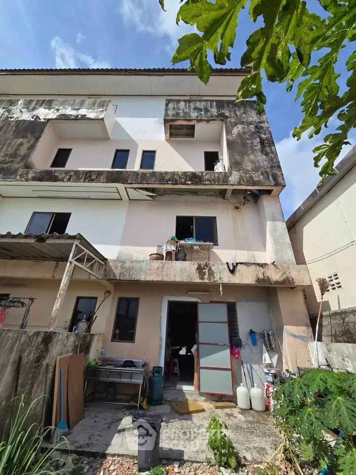 Explore this multi-story residential building with potential for renovation, featuring outdoor space and unique architecture.