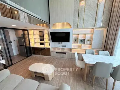 Luxurious modern living room with open kitchen, elegant decor, and natural light.