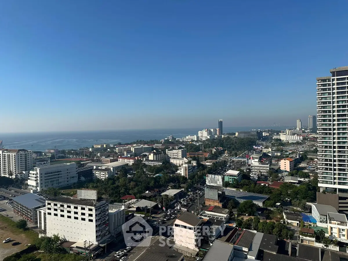 Stunning cityscape view from high-rise building with ocean in the background.