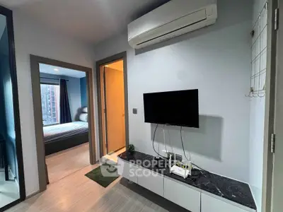 Modern apartment interior with bedroom and living area featuring sleek design and air conditioning.