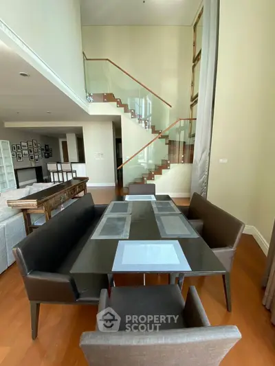 Spacious modern living room with elegant staircase and dining area in luxury apartment