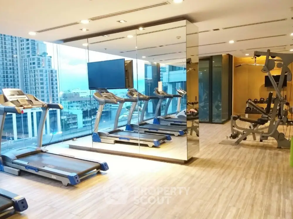 Modern gym with city view featuring treadmills and fitness equipment