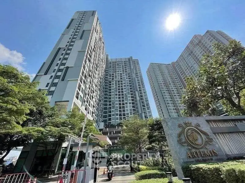Stunning high-rise residential buildings with lush greenery and clear blue sky.