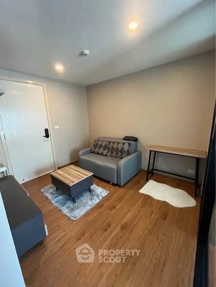 Cozy living room with modern furniture and wooden flooring in a stylish apartment.